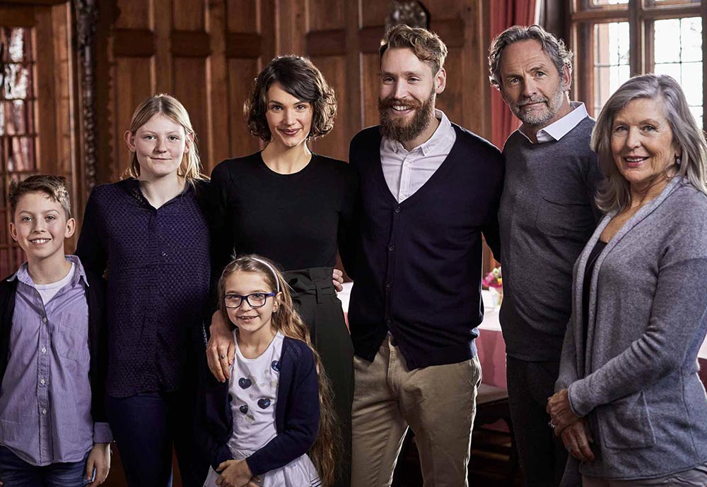 Eine Familie, bestehend aus mehreren Generationen, posiert gemeinsam für ein Familienfoto.