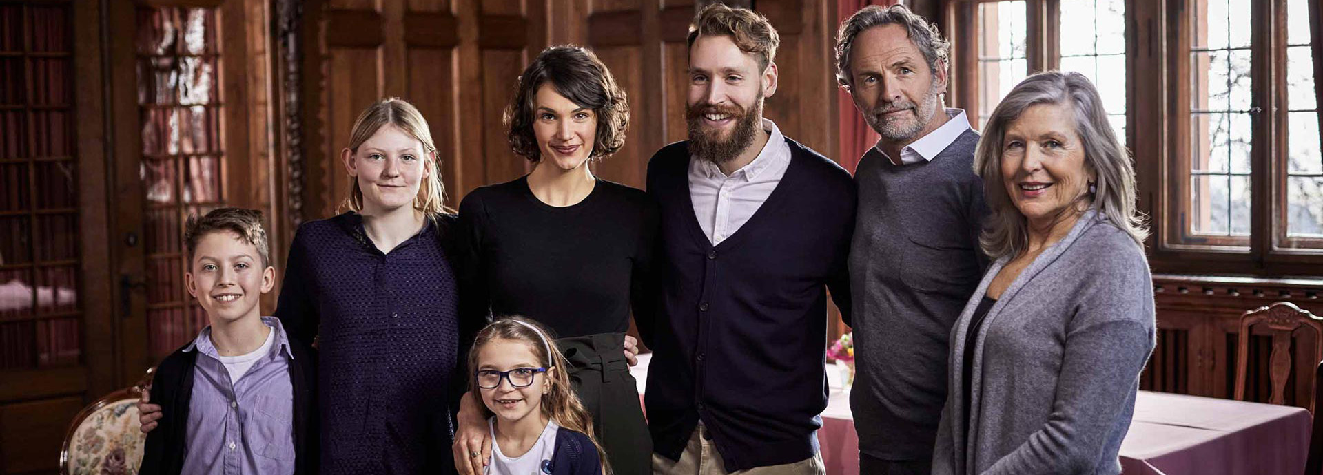 Eine Familie, bestehend aus mehreren Generationen, posiert gemeinsam für ein Familienfoto.